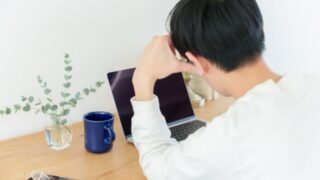 PCを見て考え込む男性