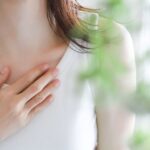 胸に手を当てる女性