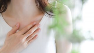 胸に手を当てる女性