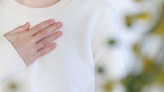 胸に手を当てる女性
