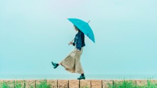 雨の中、傘をさして歩く女性