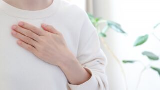 胸に手を当てる女性