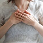 胸に手を当てる女性