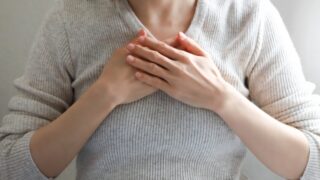 胸に手を当てる女性