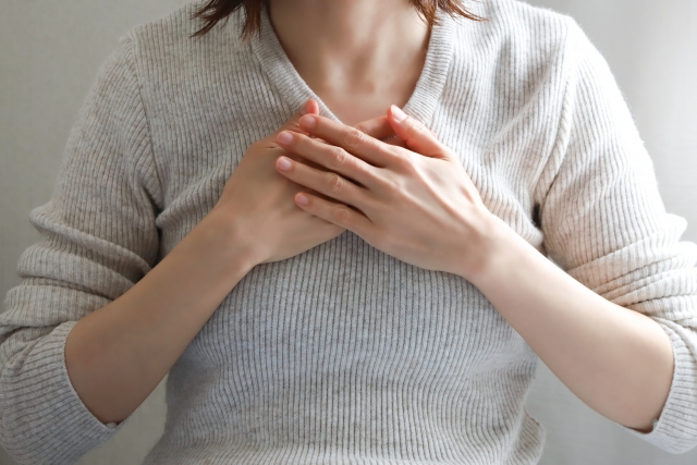 胸に手を当てる女性