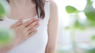胸に手を当てる女性