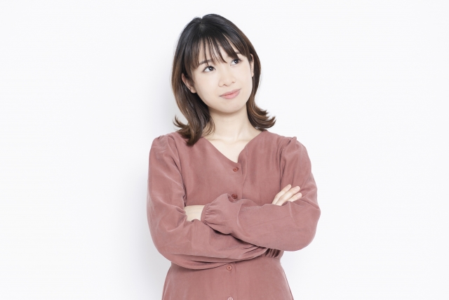 腕を組んで考え込む女性