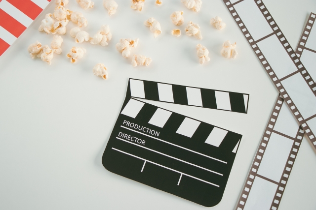 映画のカチンコとポップコーンの写真